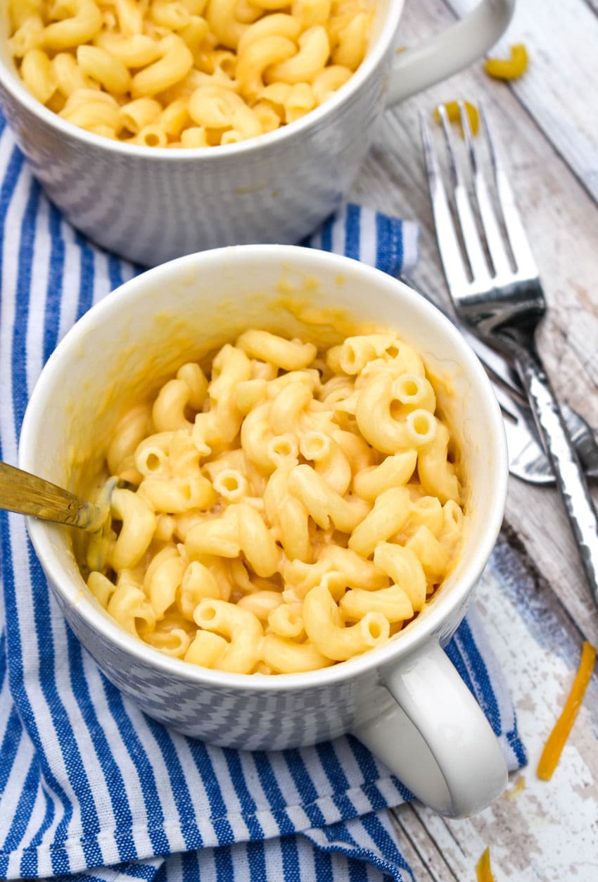 two white mugs filled with cheesy homemade easy mac