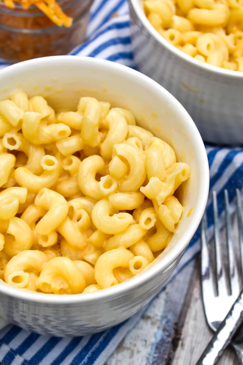 homemade easy mac in a white mug with a silver fork on the side