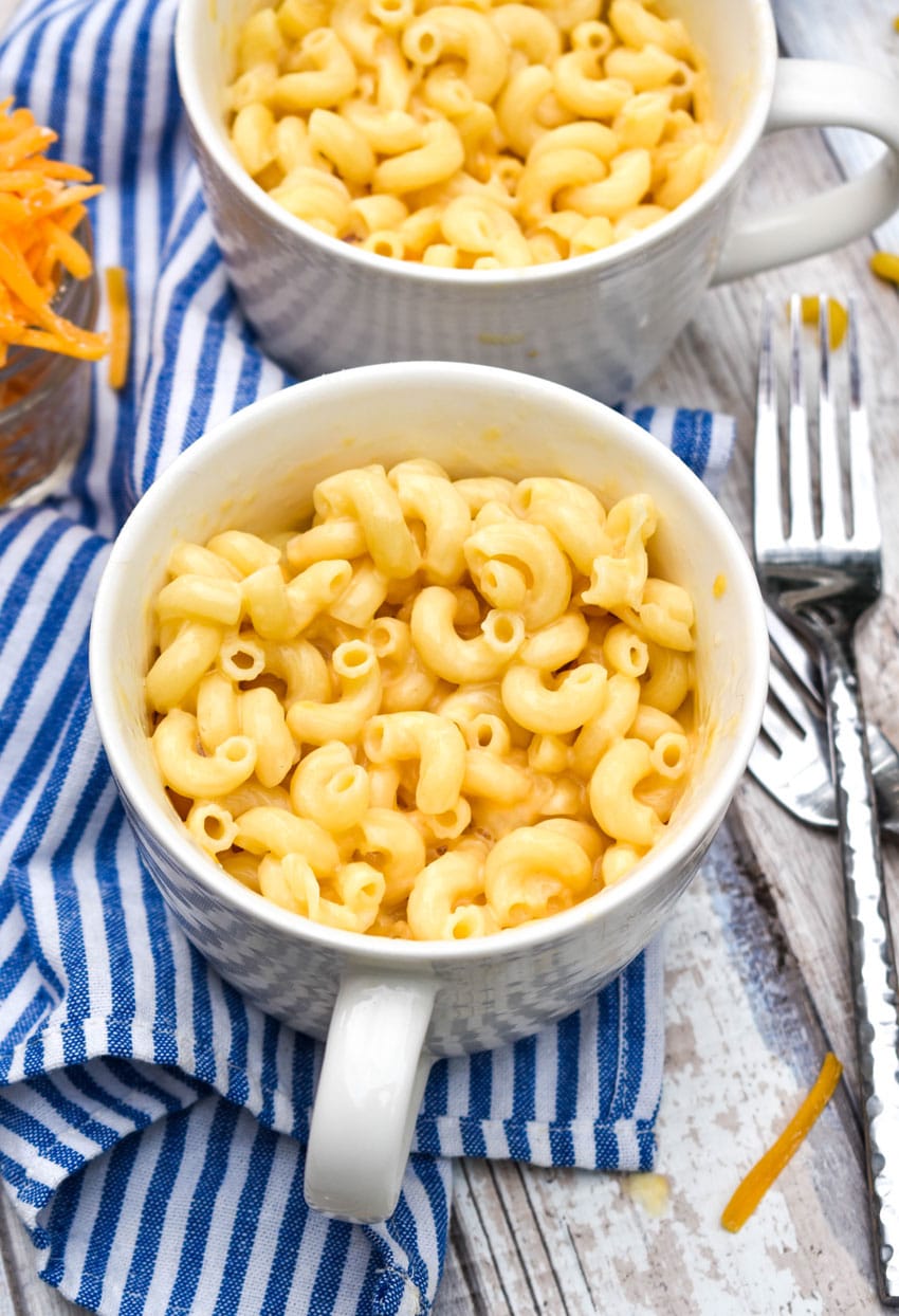 two white mugs filled with cheesy homemade easy mac