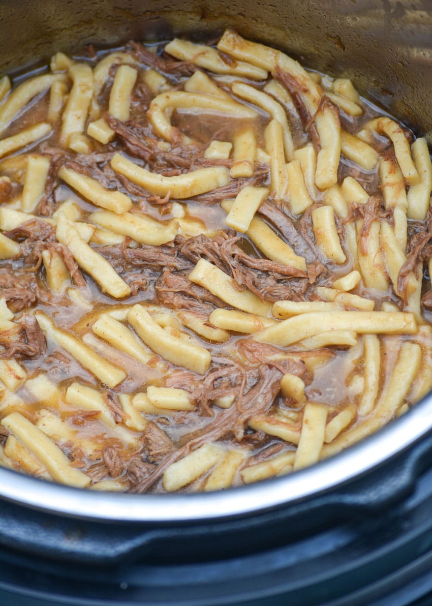 an instant pot full of beef and egg noodles in broth