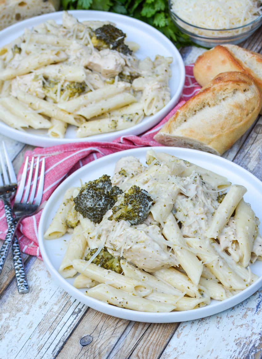 slow cooker chicken alfredo with broccoli served on white plates