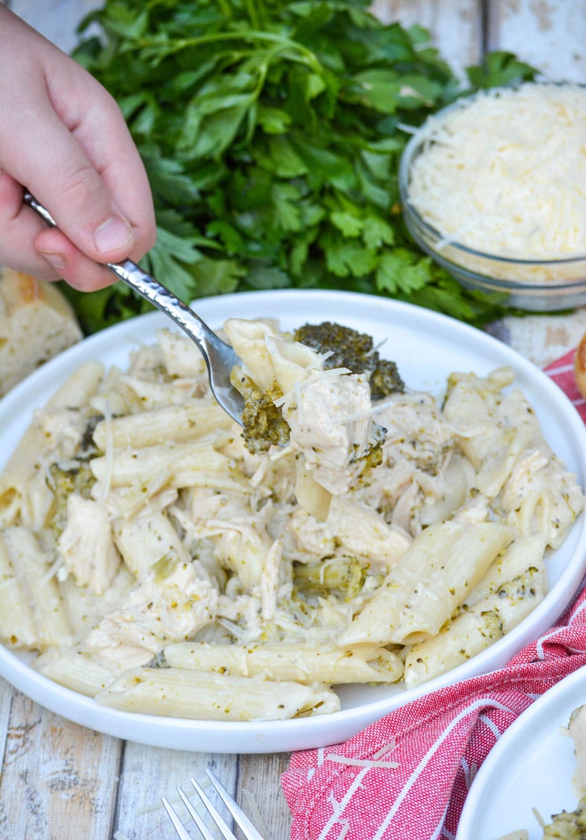 slow cooker chicken alfredo with broccoli served on white plates