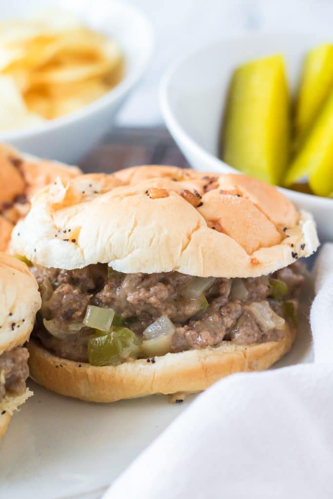 slow cooker philly cheesesteak sloppy joe sandwiches arranged on a white plate