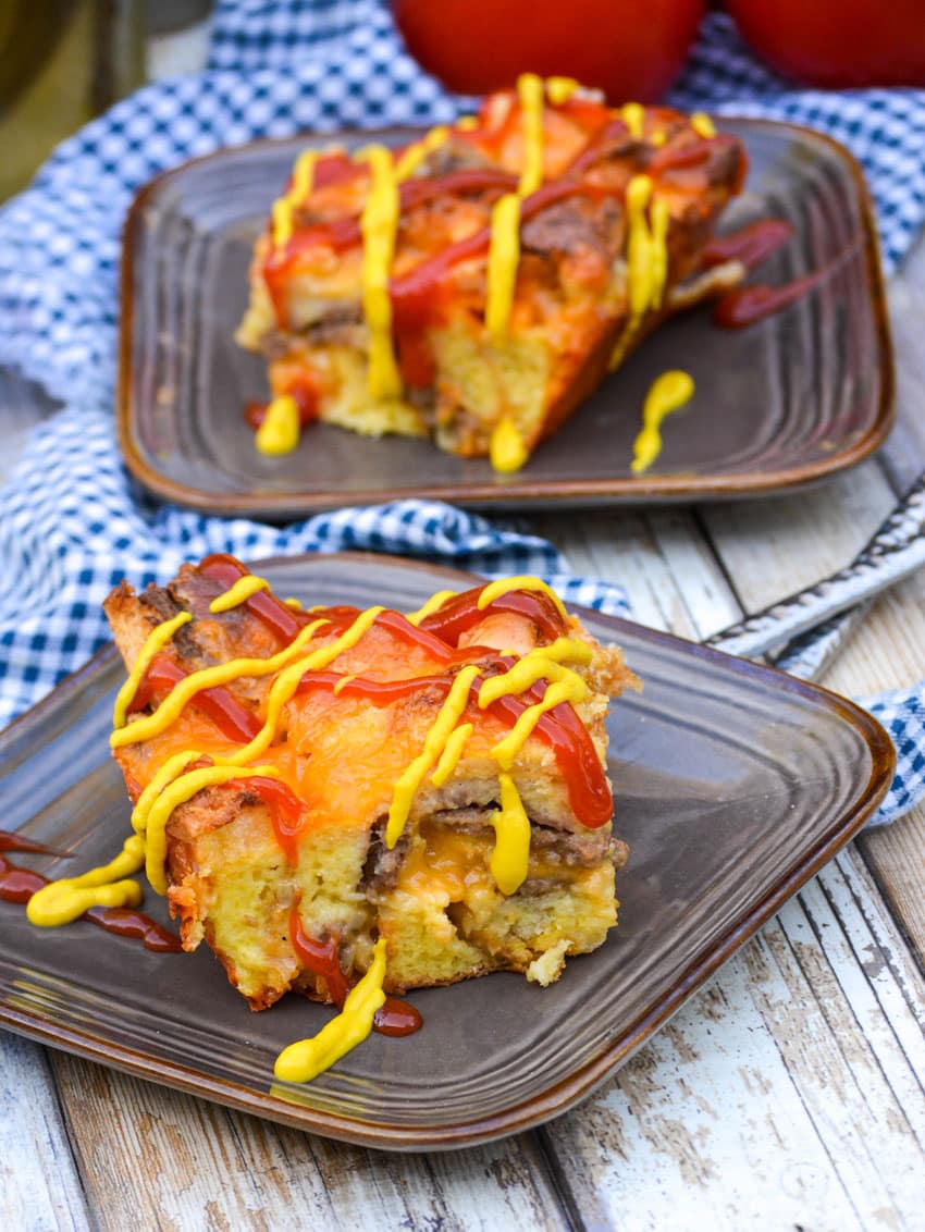 two slices of cheeseburger bread pudding on small brown plates