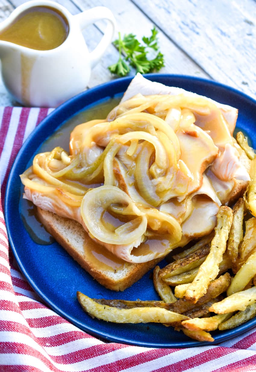 Diner Style Hot Turkey Sandwiches on a blue plate with crispy french fries on the side