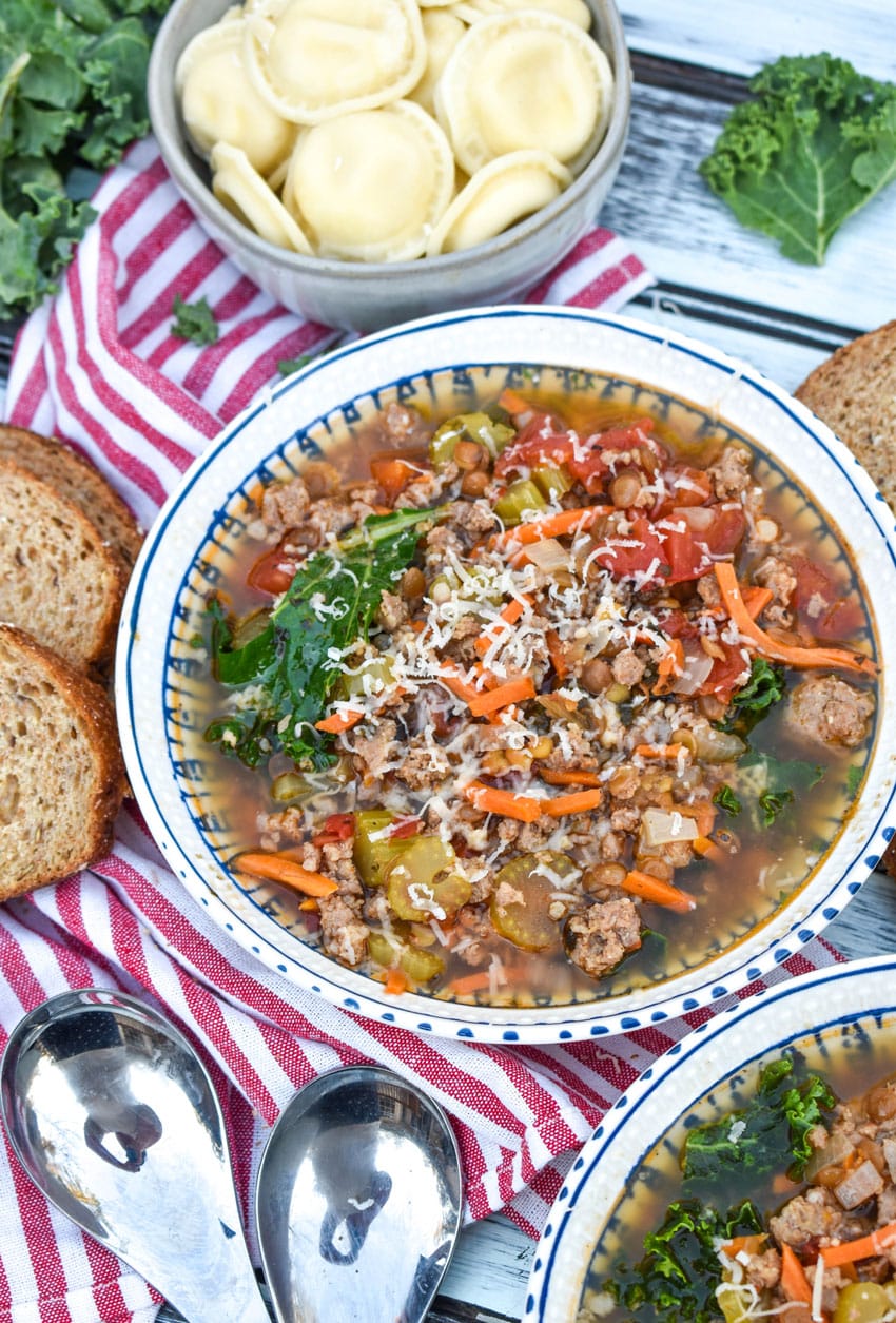 a white bowl filled with easy sausage soup with kale