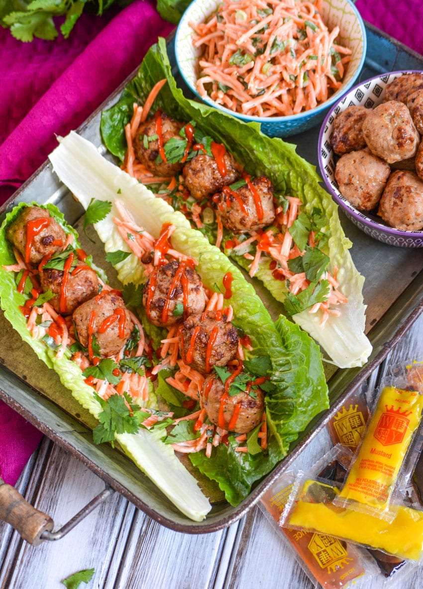 teriyaki meatball lettuce wraps drizzled with sriracha sauce on a silver tray