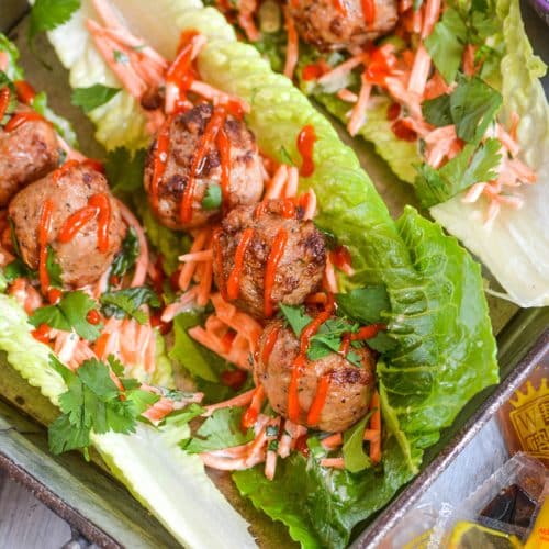 teriyaki meatball lettuce wraps drizzled with sriracha sauce on a silver tray