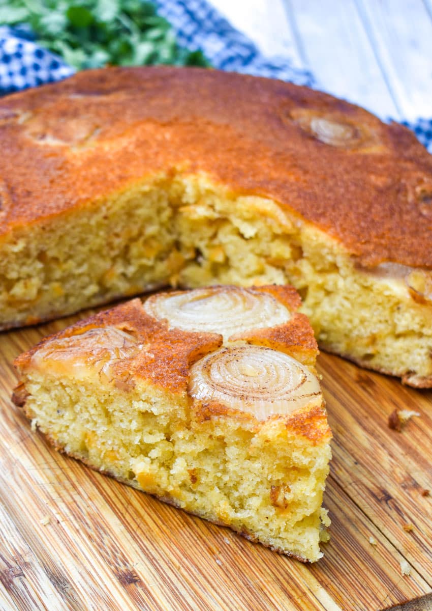 sliced upside down cornbread with onions on a wooden cutting board