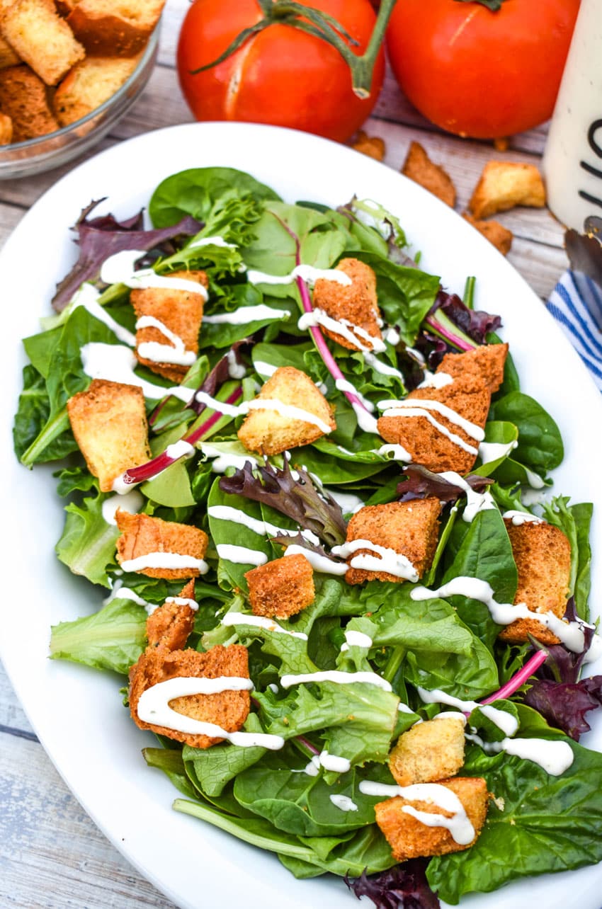 crispy air fryer croutons in a simple salad in a white serving dish