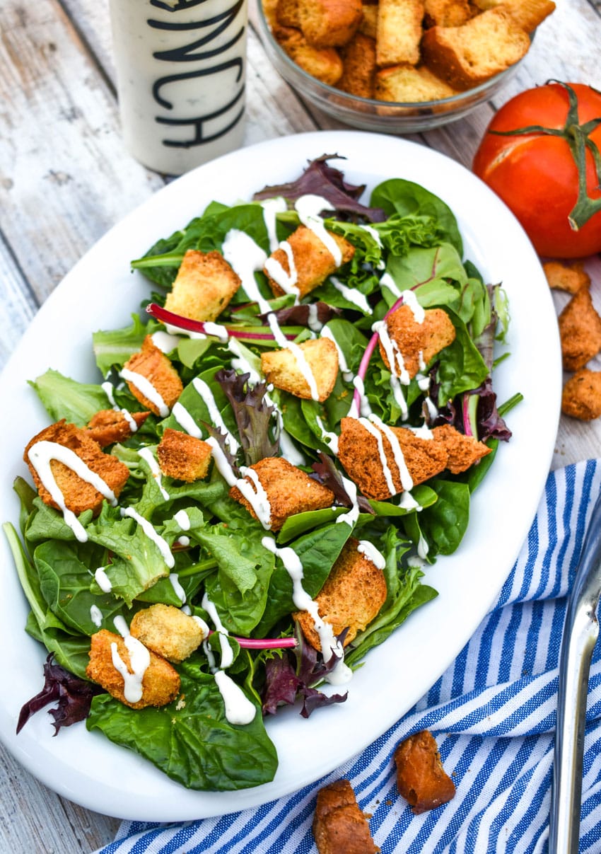 crispy air fryer croutons in a simple salad in a white serving dish