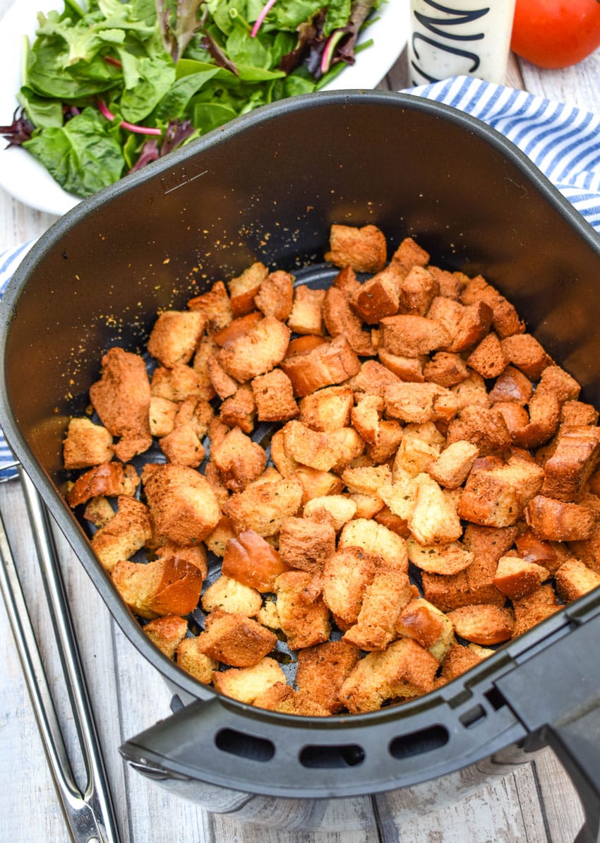 seasoned homemade croutons in the basket of an air fryer
