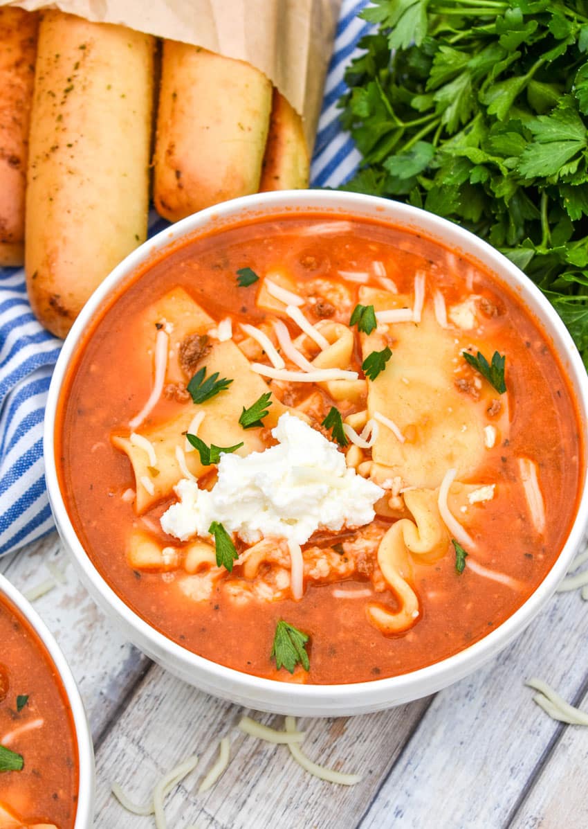 Quick & Easy Lasagna Soup (Slow Cooker Recipe) a white bowl filled with slow cooker lasagna soup