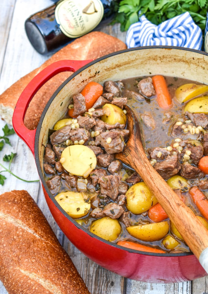 a wooden spoon in a pot of guinness beef stew with barley