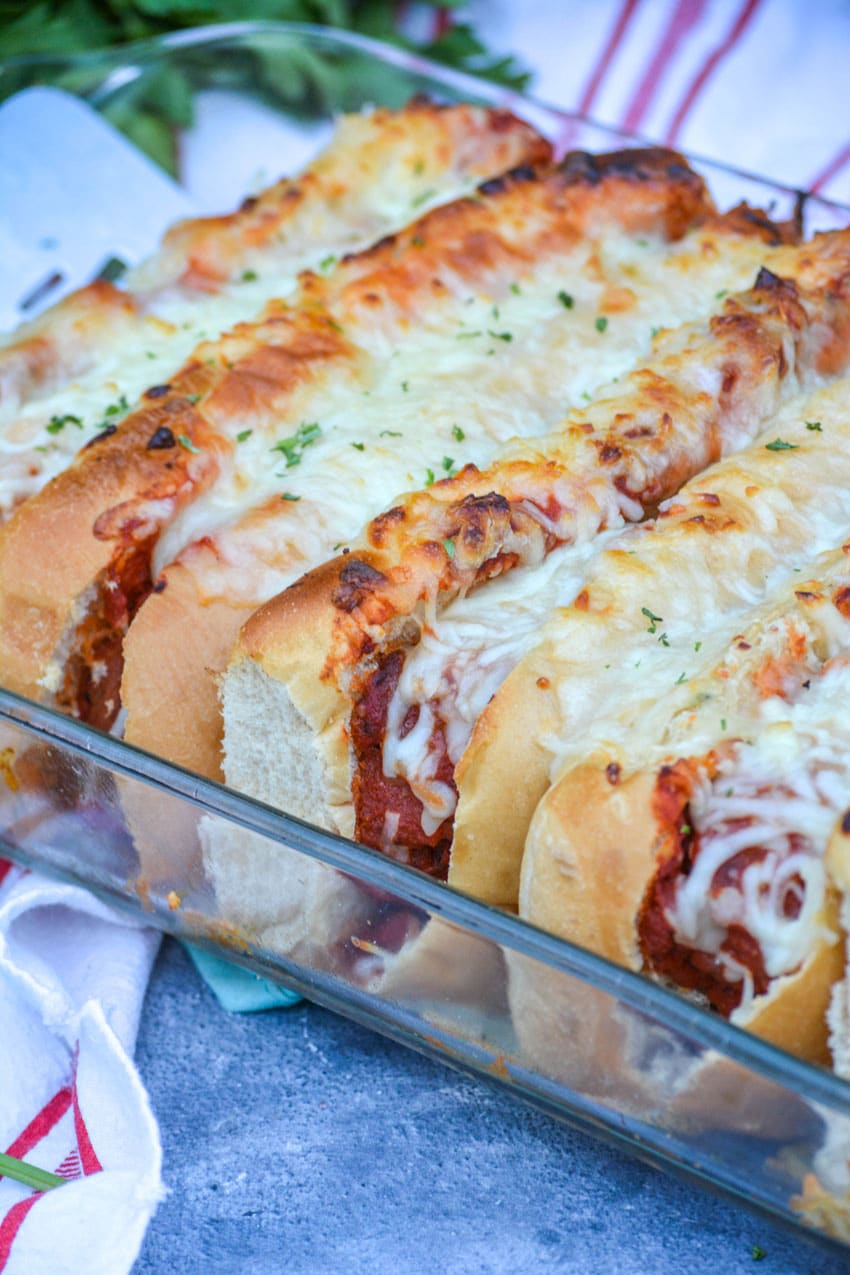 cheesy oven baked meatball subs in a glass baking dish