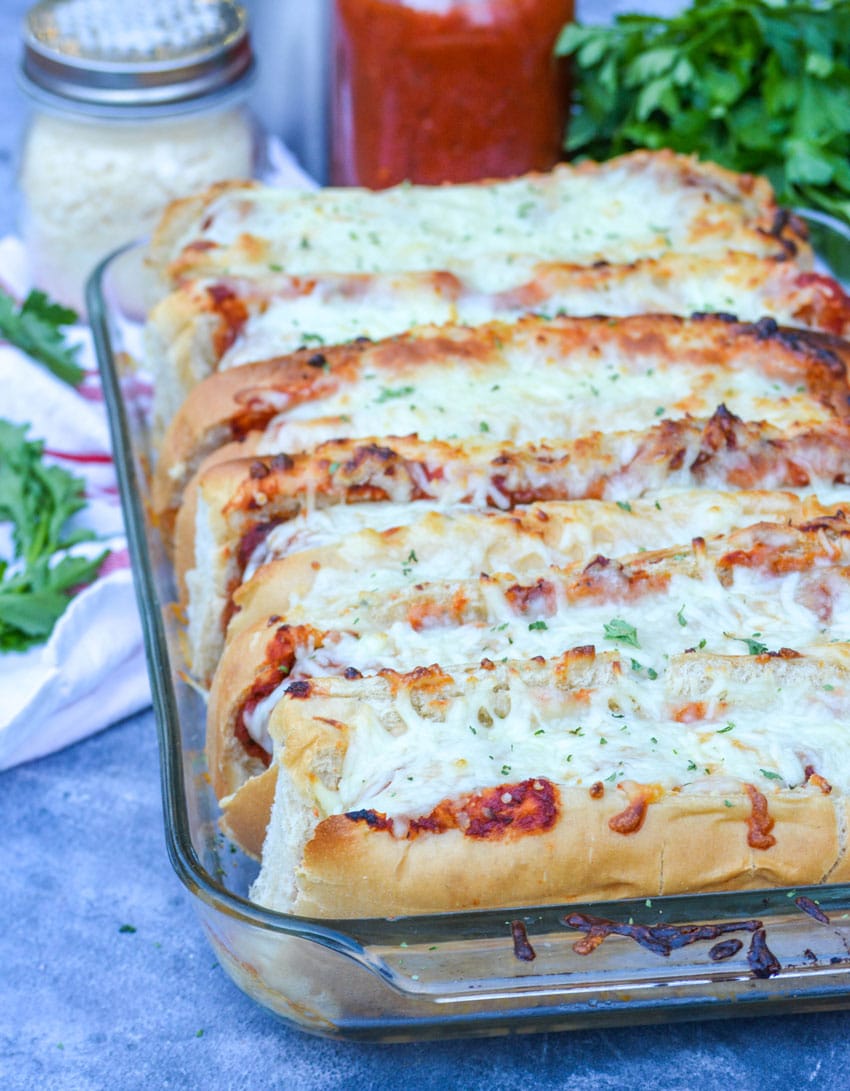 cheesy oven baked meatball subs in a glass baking dish