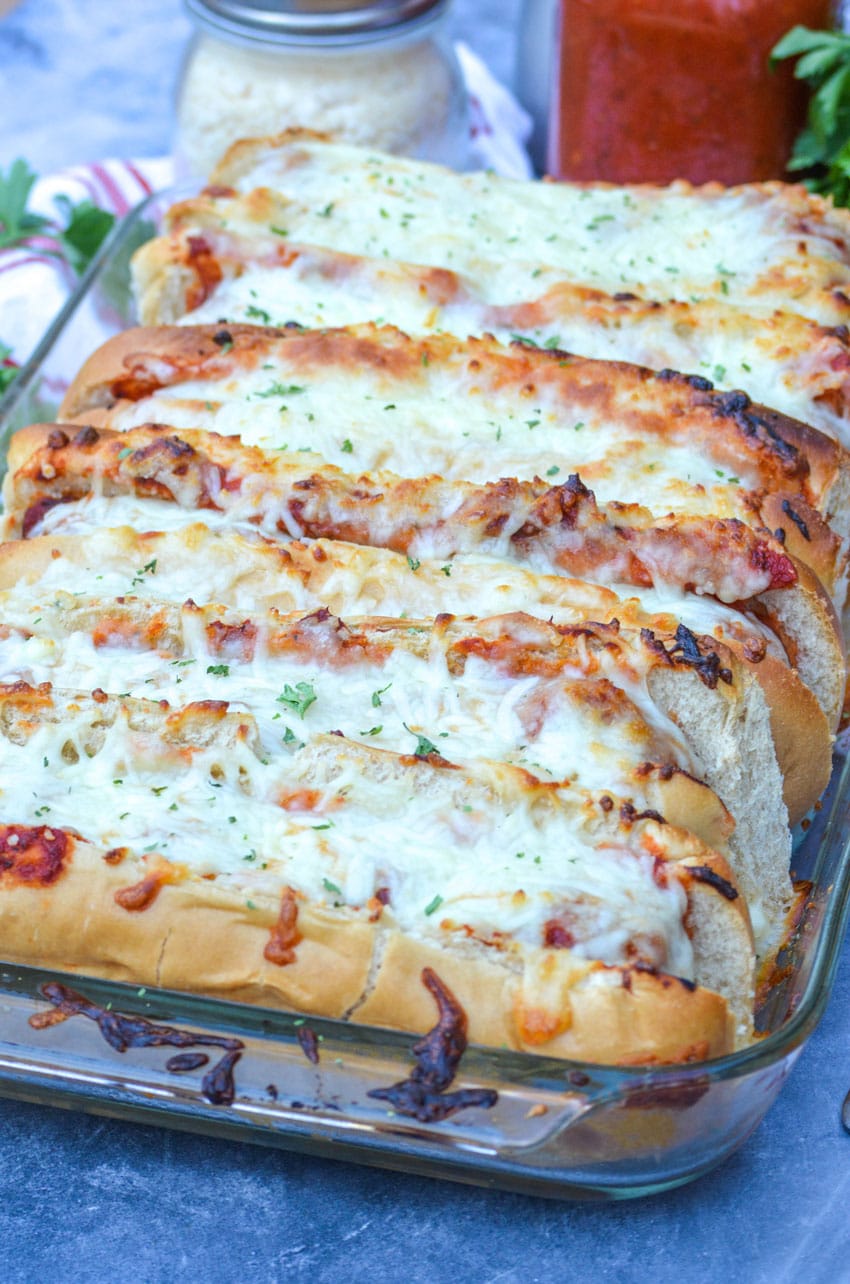 cheesy oven baked meatball subs in a glass baking dish