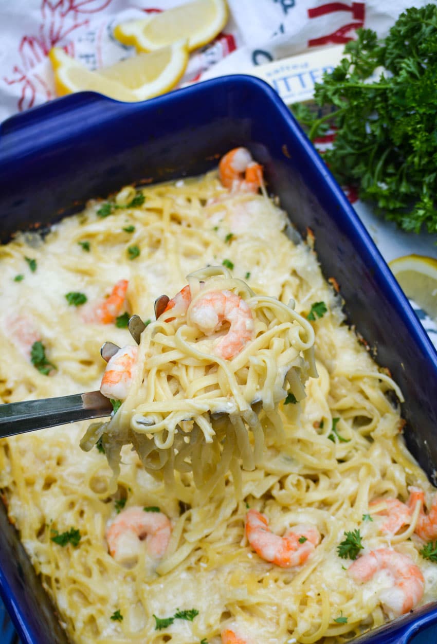 a silver spoon holding up a scoop of baked shrimp scampi linguini