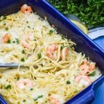 a silver spatula in a blue dish filled with shrimp scampi casserole