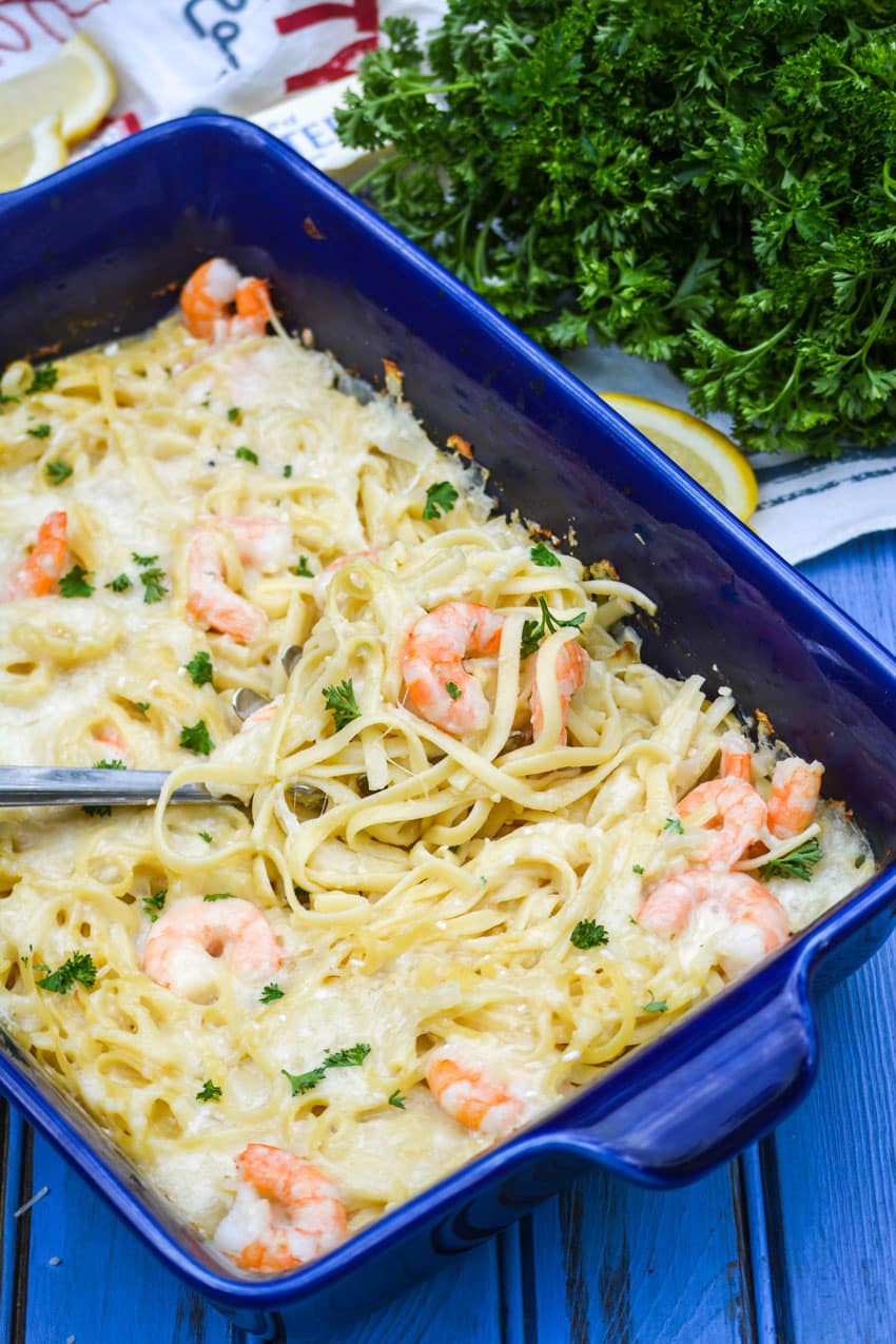 a silver spatula in a blue dish filled with shrimp scampi casserole