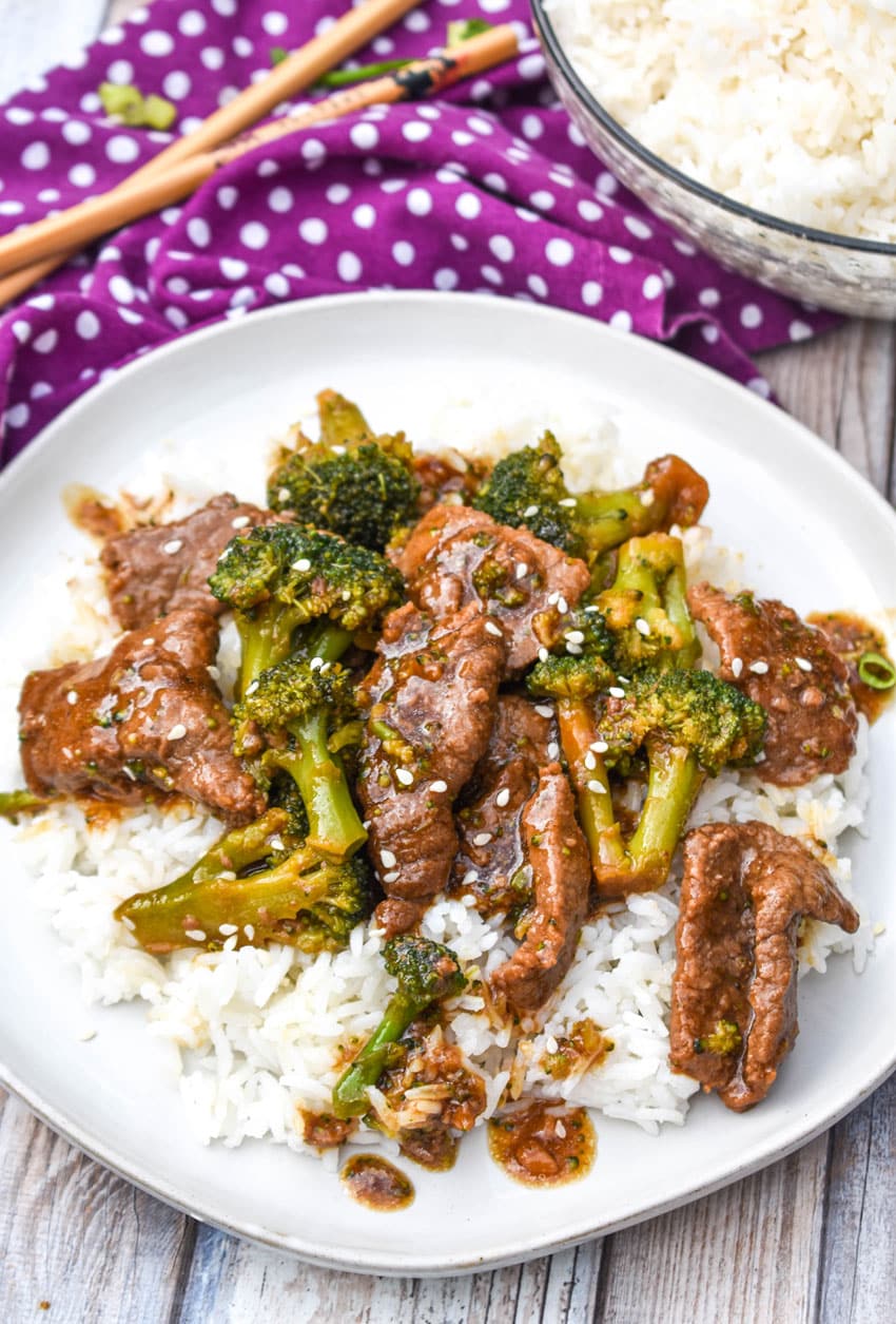 Slow Cooker Beef & Broccoli slow cooker beef and broccoli over steamed white rice on a white plate