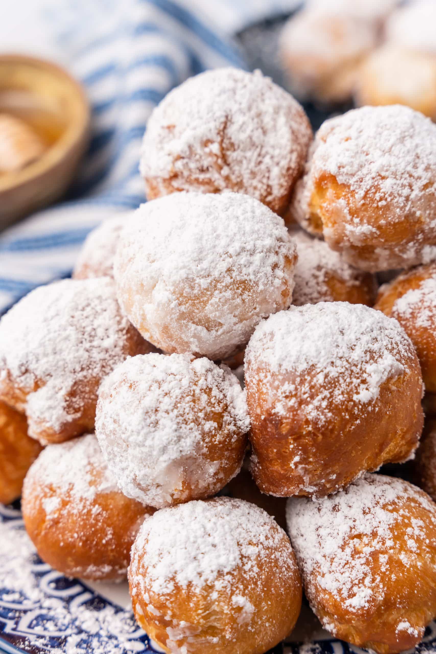 canned biscuit beignets piled on a blue and white plate