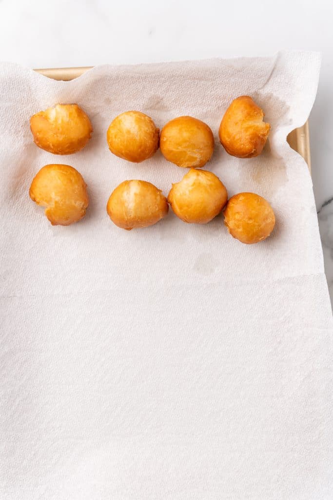 fried beignets on a paper towel lined pan