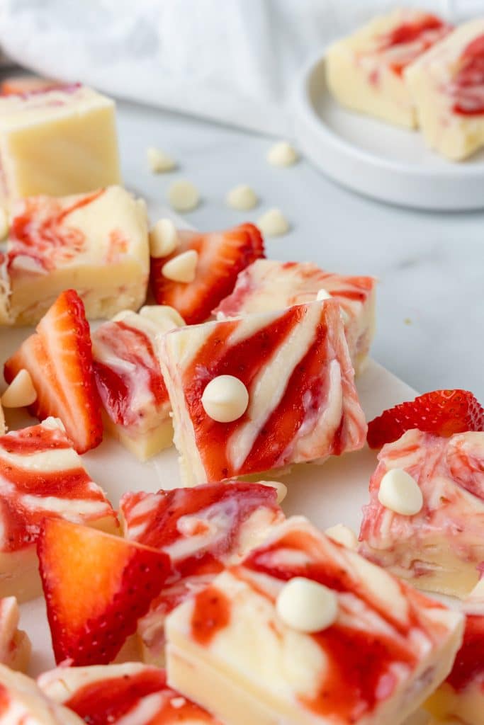 squares of strawberry and cream fudge on a white cutting board