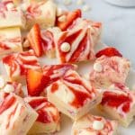 squares of strawberries and cream fudge on a marble counter top