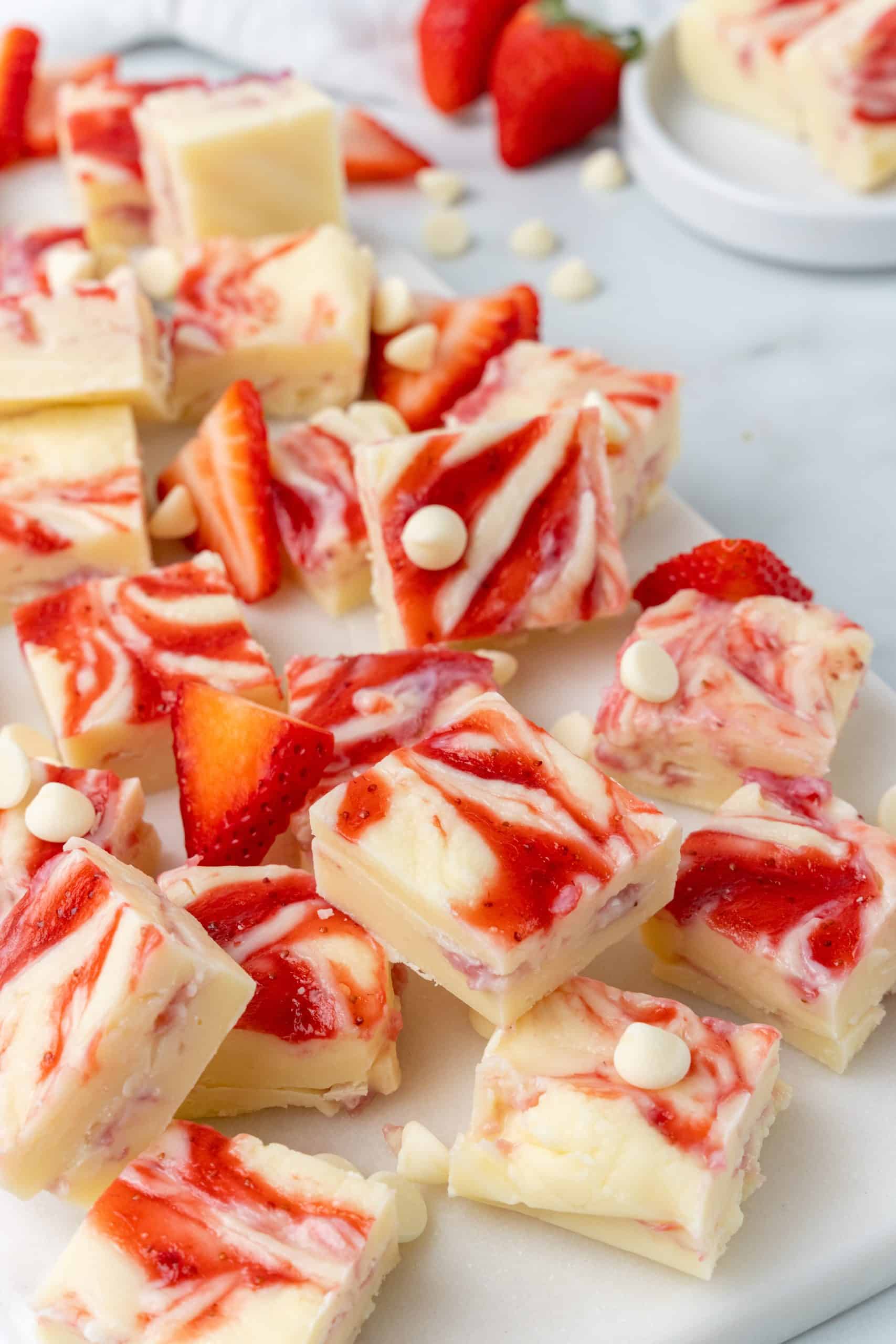 squares of strawberries and cream fudge on a marble counter top