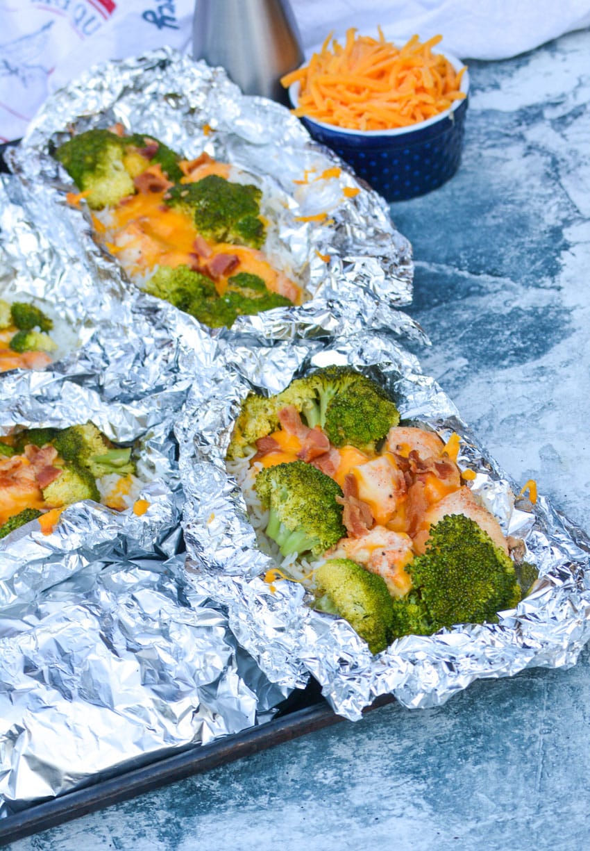 opened cheesy chicken broccoli rice foil packets on a sheet pan