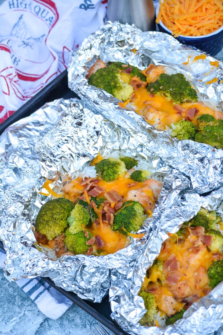 opened cheesy chicken broccoli rice foil packets on a sheet pan