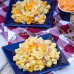macaroni and cheese with ham on two small blue plates