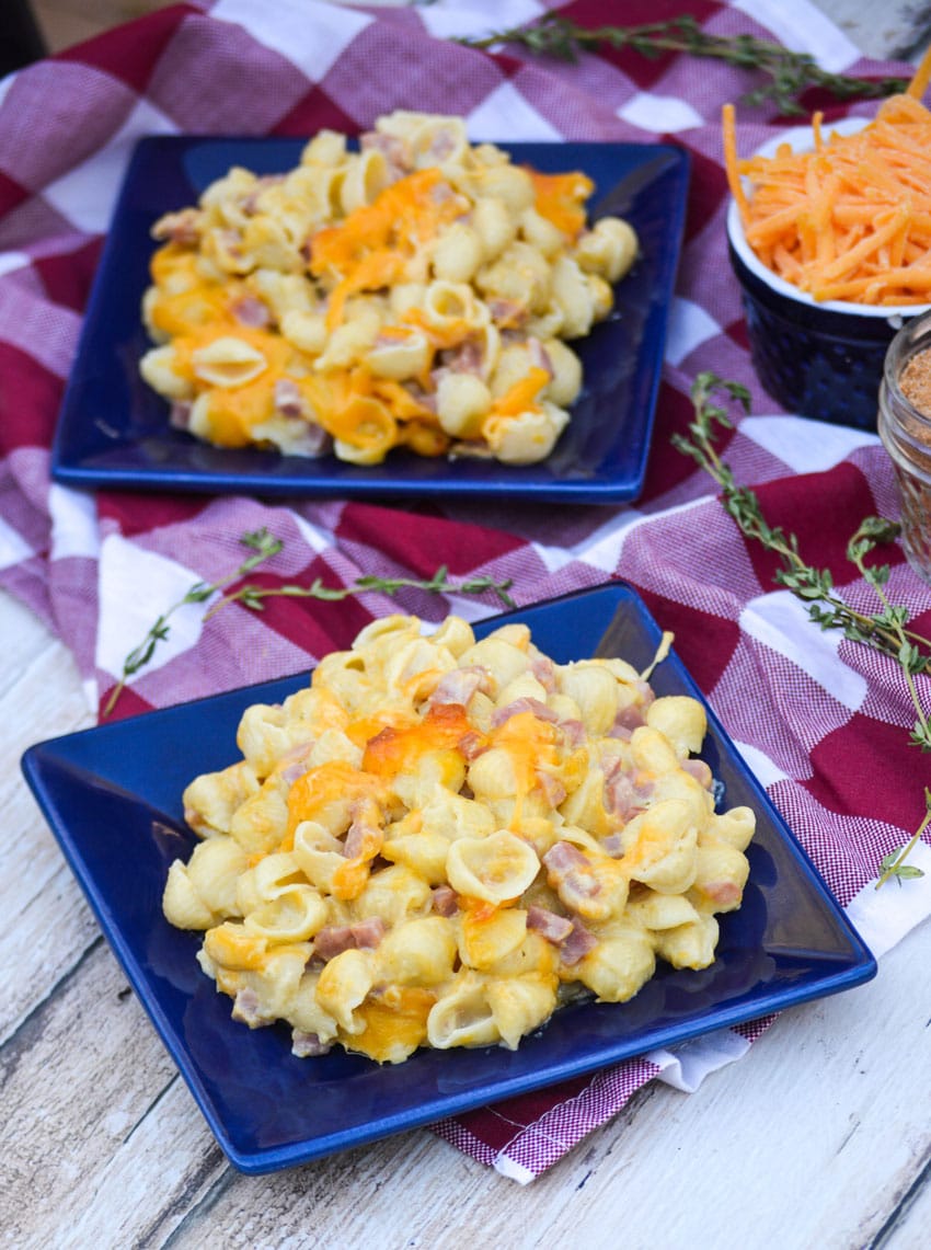 macaroni and cheese with ham on two small blue plates