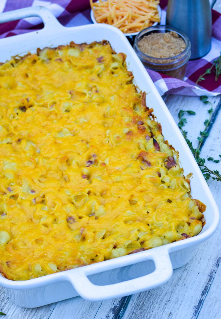 baked macaroni and cheese with ham in a white casserole dish