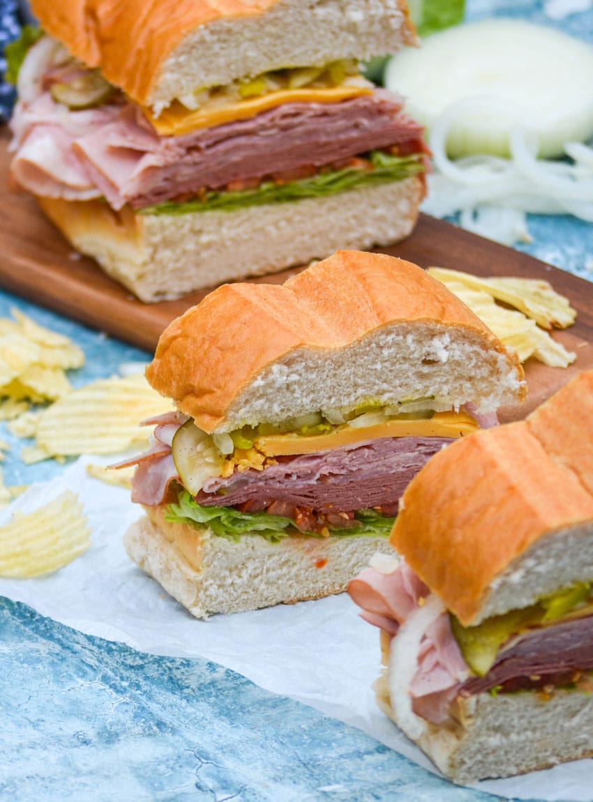 sliced deli style sub sandwiches on white parchment paper