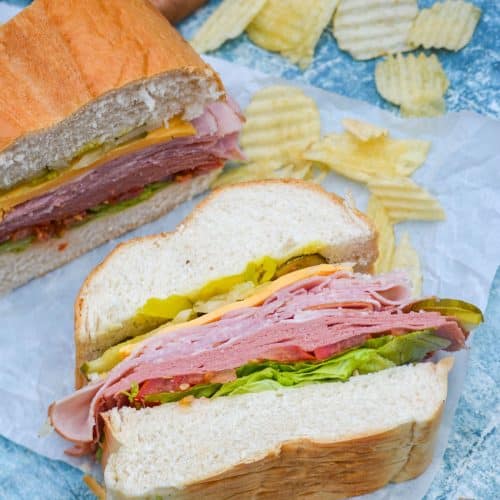 sliced Italian American sub sandwiches on white parchment paper