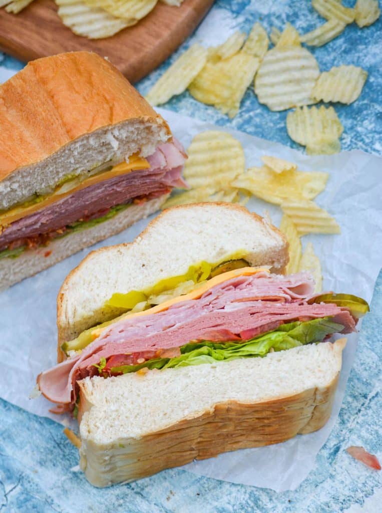 sliced Italian American sub sandwiches on white parchment paper