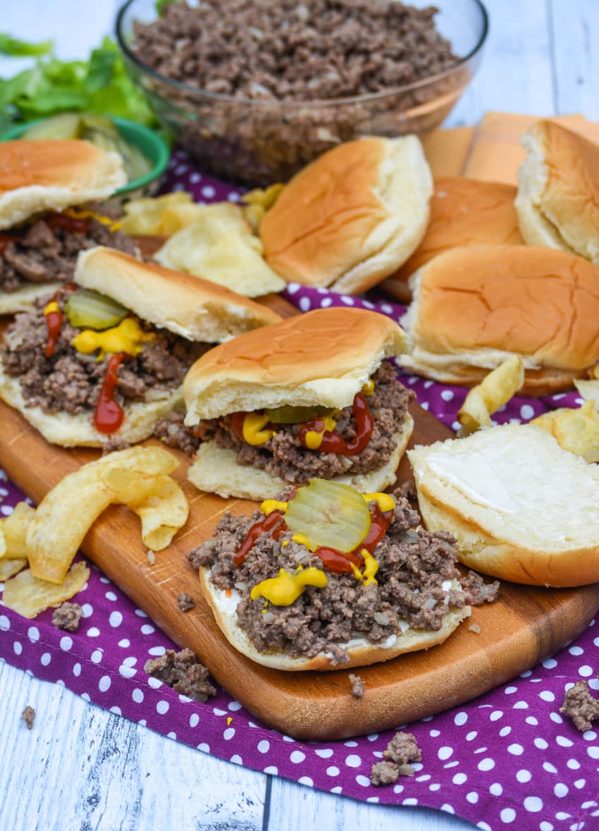 loose meat sandwiches on a wooden cutting board