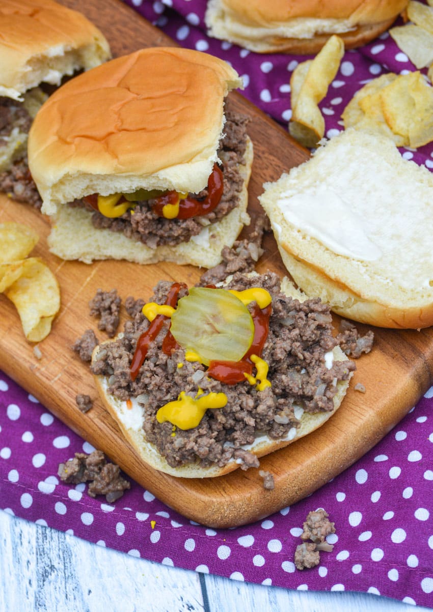 loose meat sandwiches on a wooden cutting board