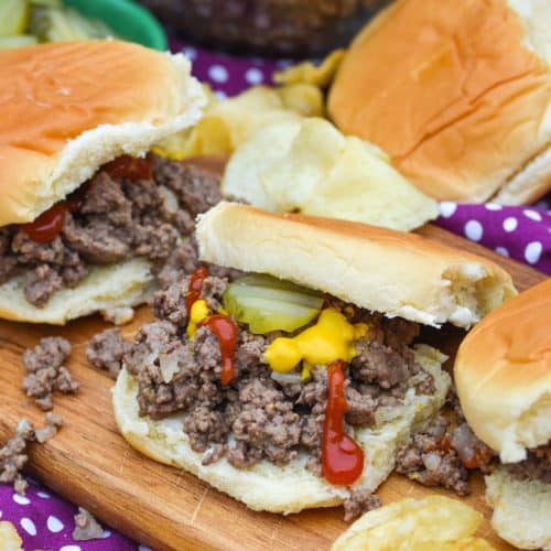 loose meat sandwiches on a wooden cutting board