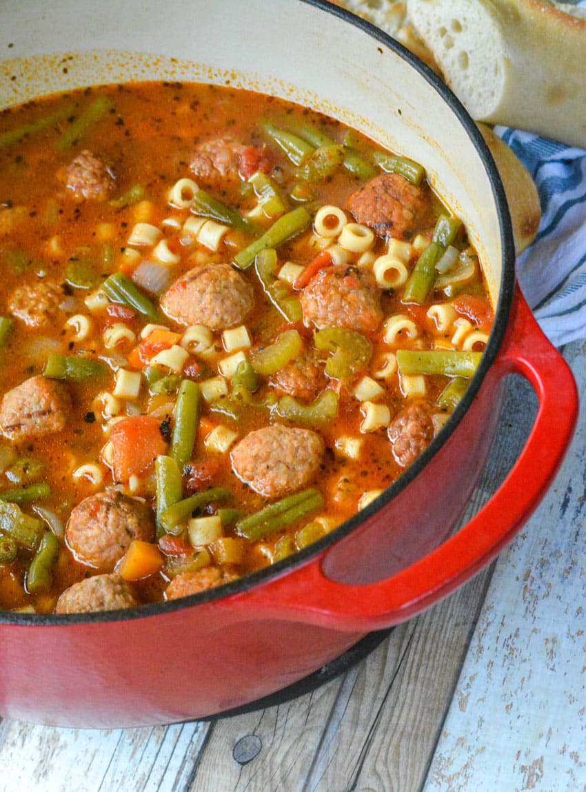 meatball vegetable soup in a red enameled cast iron pot