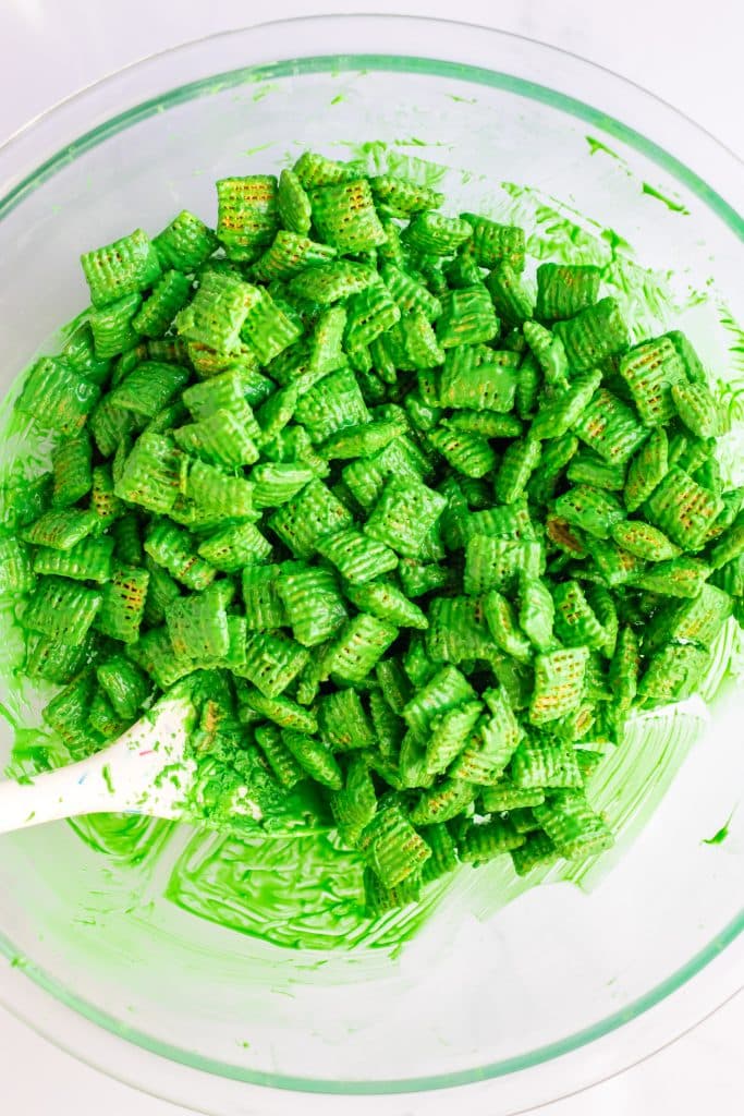green chocolate coated chex cereal in a glass mixing bowl