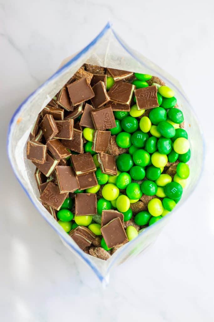mint chocolate candy and green muddy buddies in a large ziplocking bag