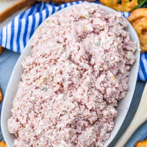 old fashioned bologna salad in a white dish with a wooden spoon on the side