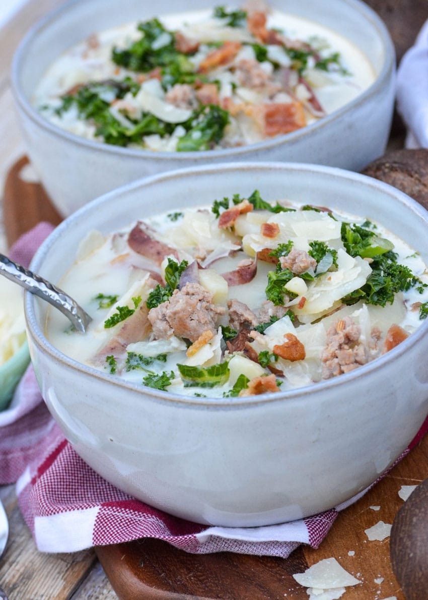 a gray bowl filled with copycat olive garden zuppa toscana soup topped with bacon