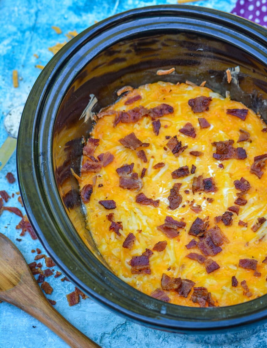Slow cooker cheddar bacon ranch hash browns in the black bowl of a slow cooker