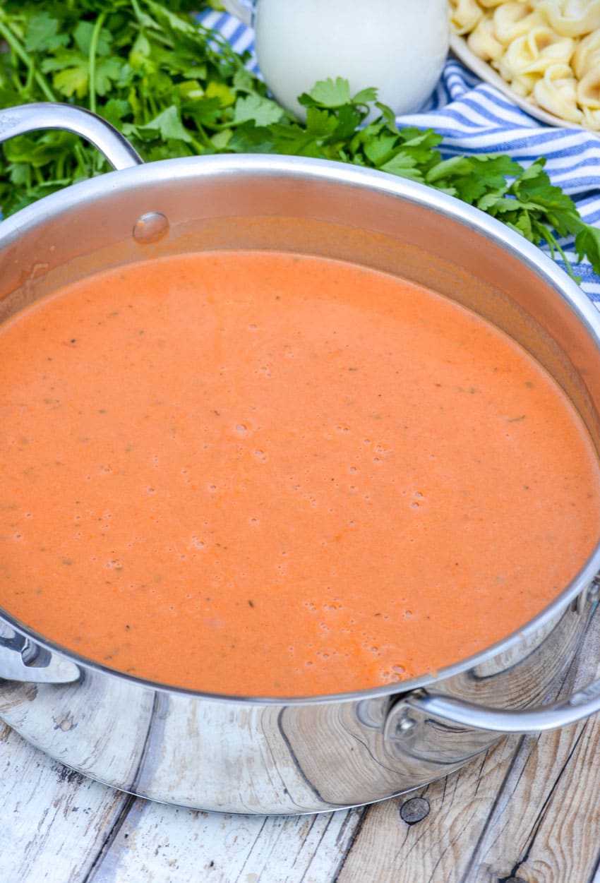 creamy three ingredient tomato soup in a metal sauce pan