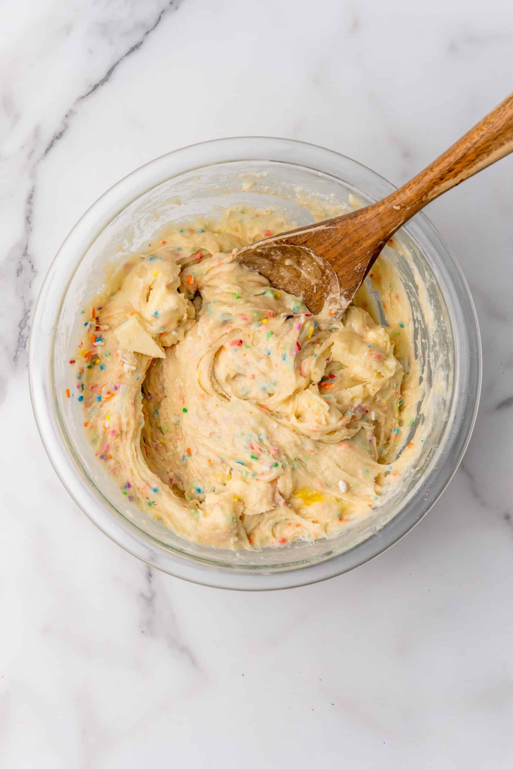birthday cake blondie batter in a glass mixing bowl