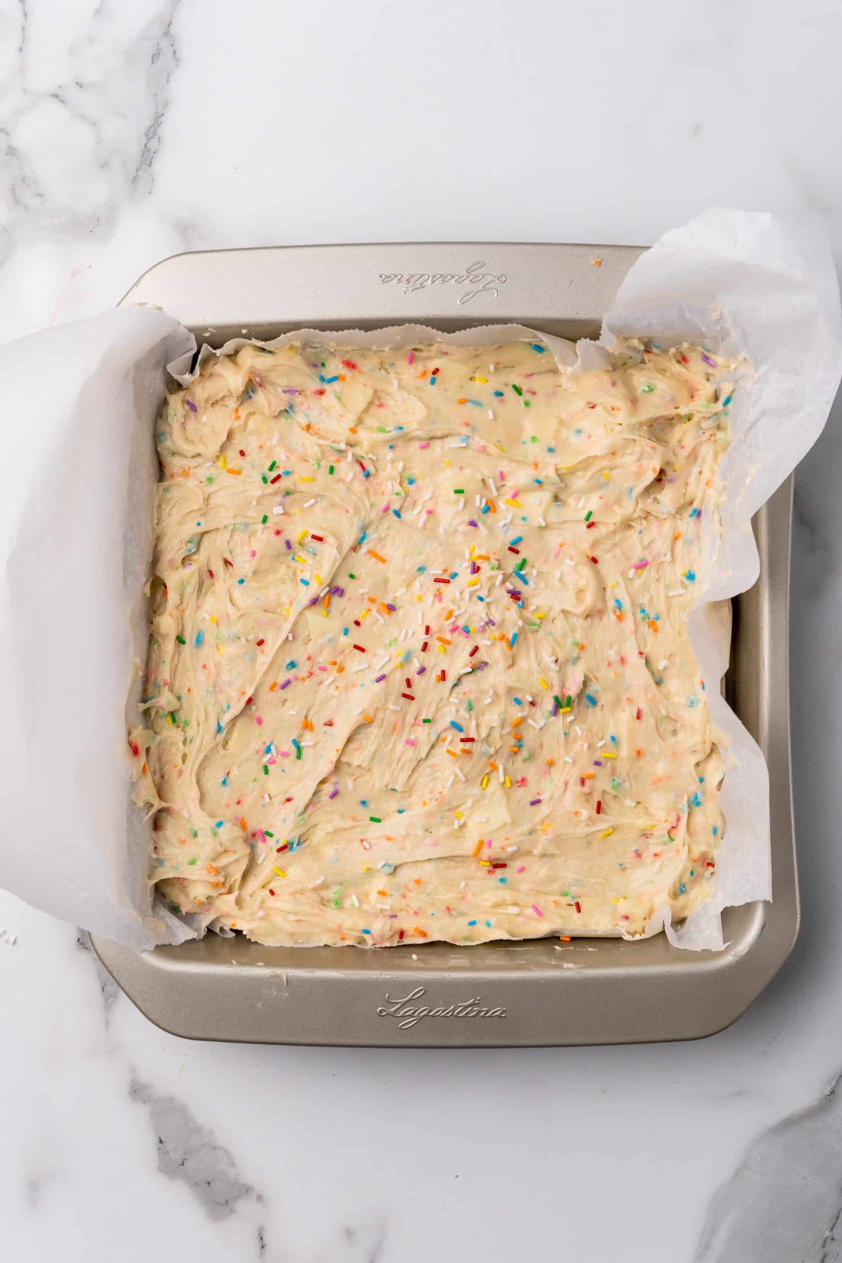 funfetti cake batter mix in a parchment paper lined baking pan